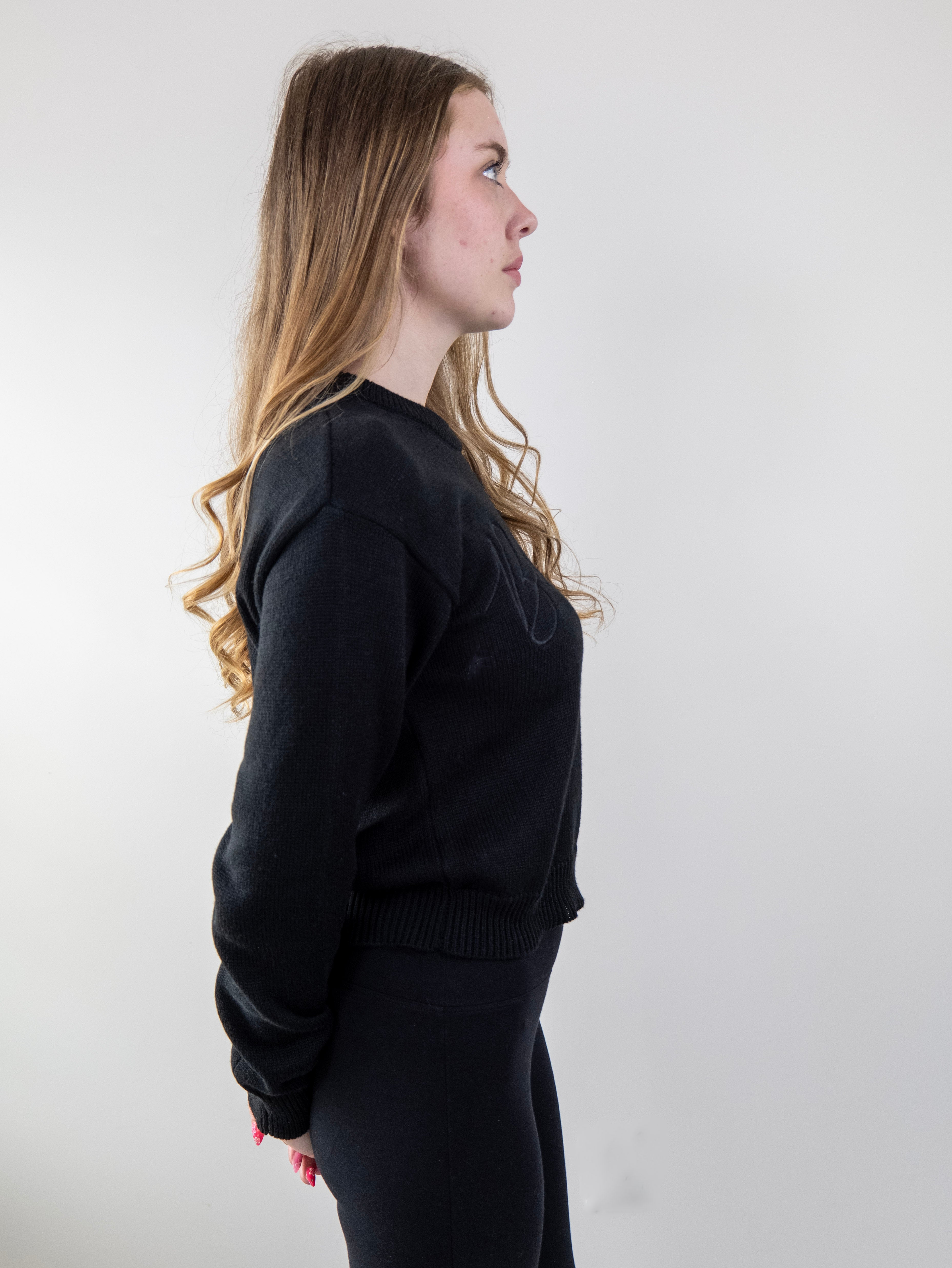 Side view of model wearing black knit sweater