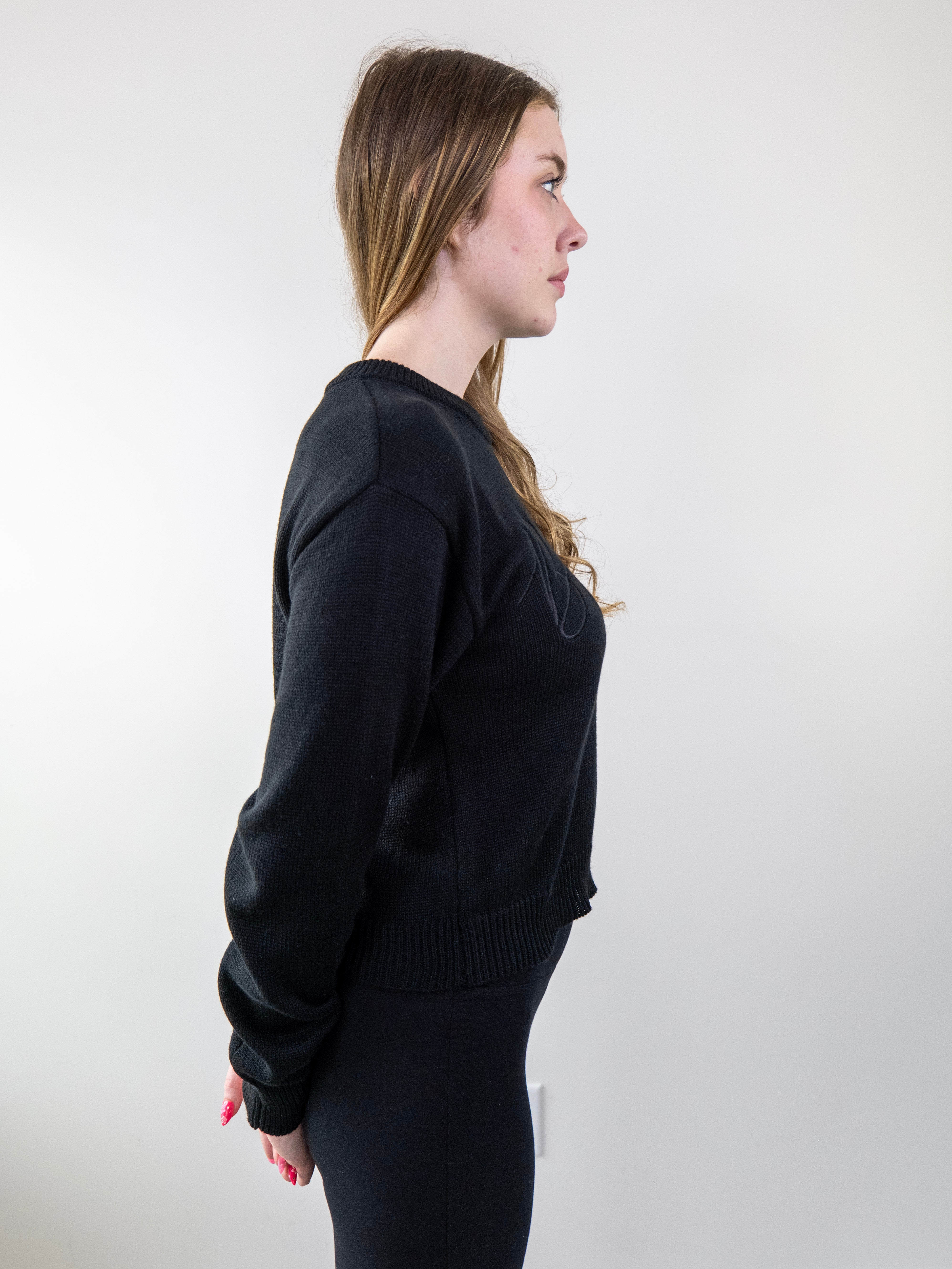 Side view of model wearing black knit sweater