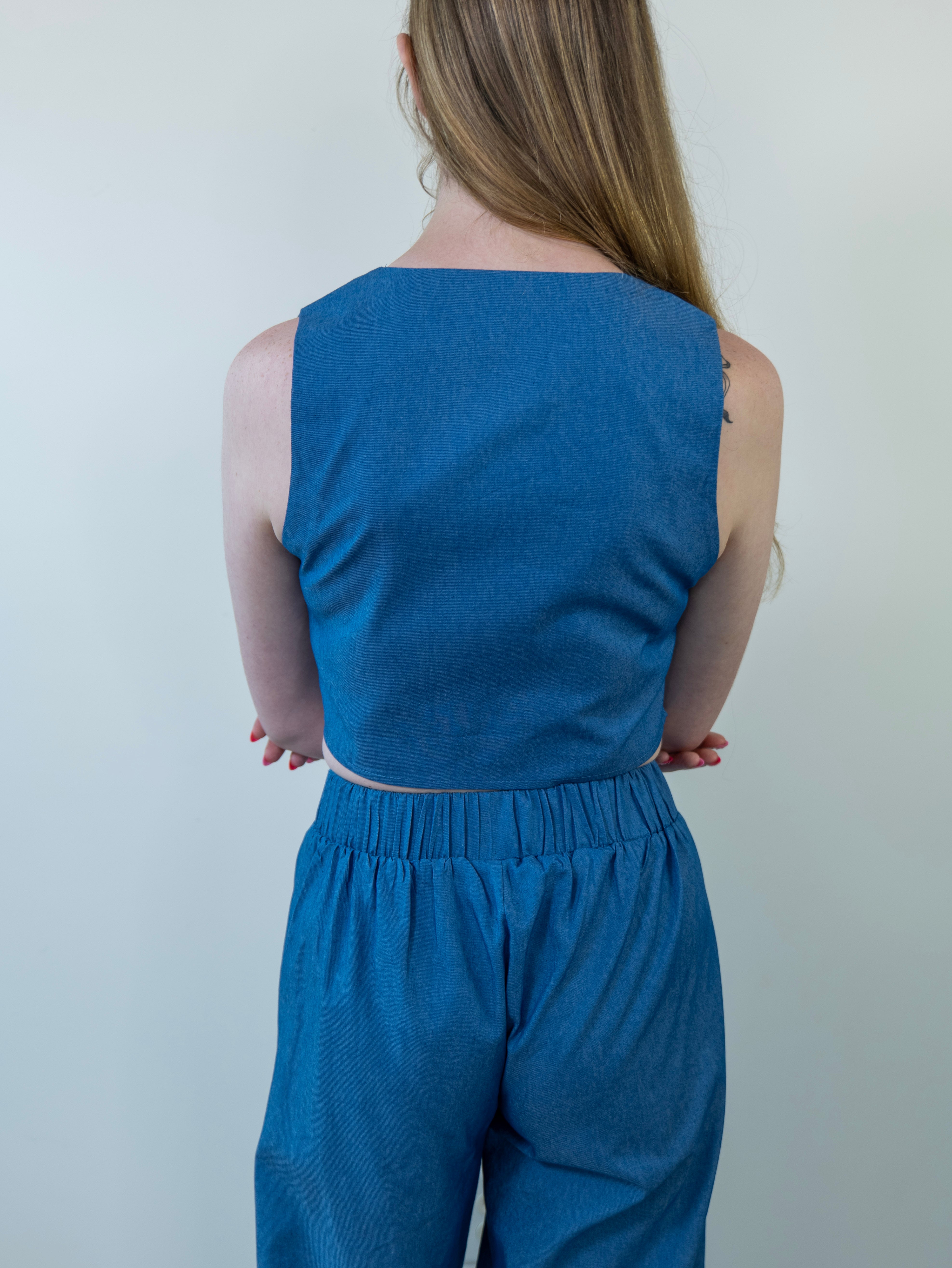 Model wearing denim-print vest, close-up from waist up