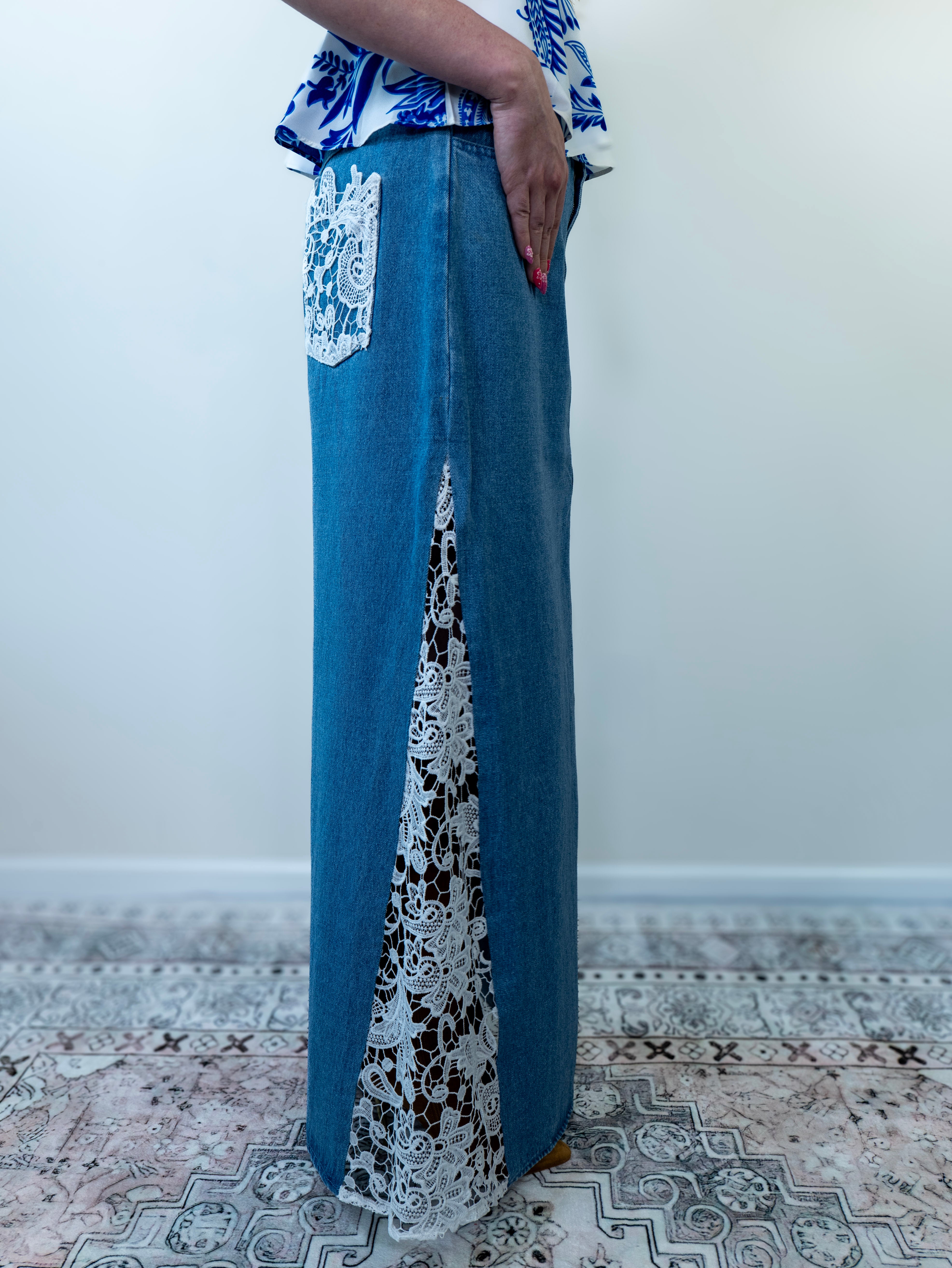 Model standing in denim blue crochet maxi skirt, angled front view