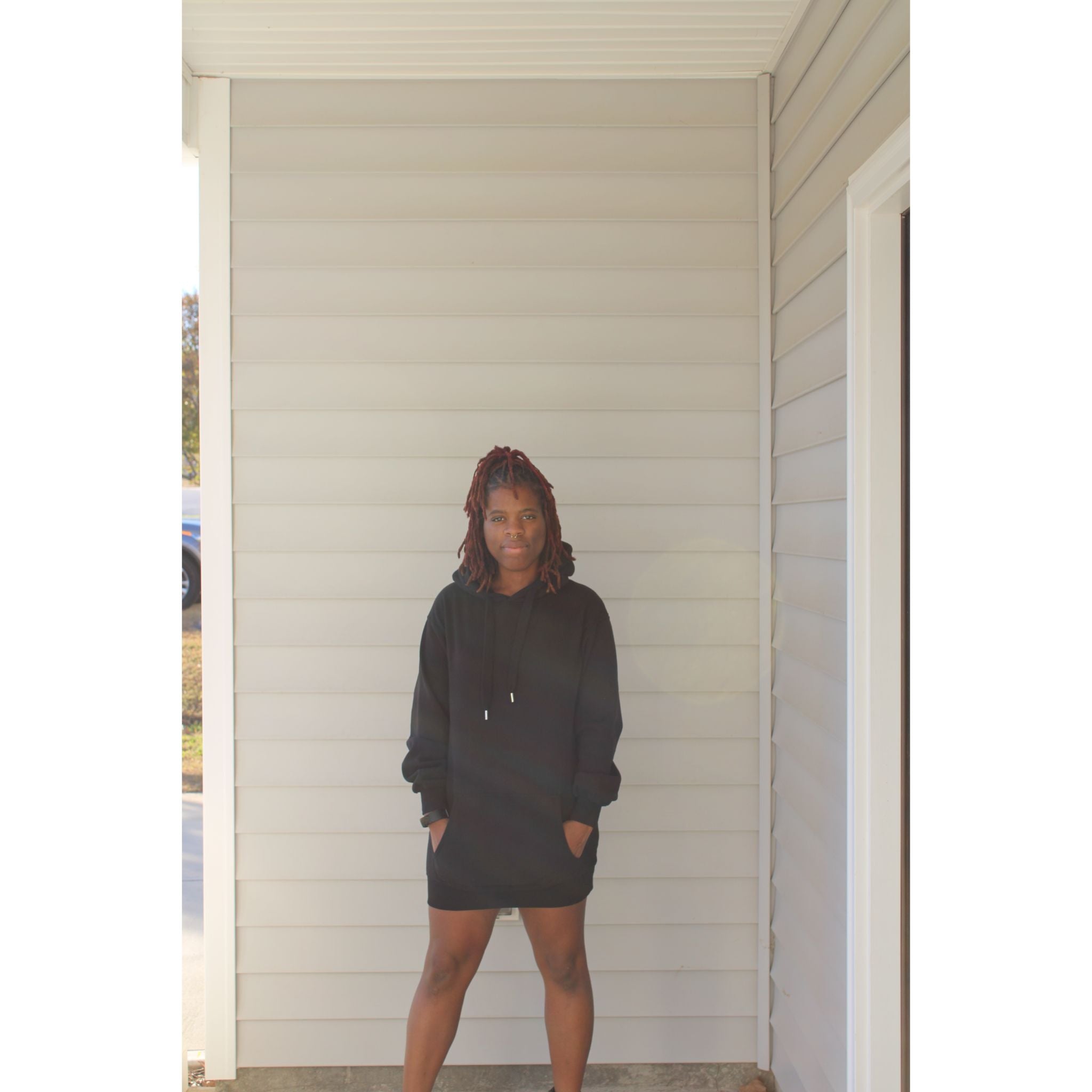 Black oversized hoodie with thick drawstring, kangaroo pocket, and long sleeves for a cozy, relaxed fit. Model wearing only the hoodie to show the length she is 5'4'