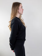 Side view of model wearing black knit sweater