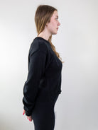 Side view of model wearing black knit sweater