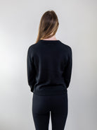 Back view of black long-sleeve knit sweater
