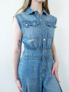 Close-up of button-down chest detail on denim jumpsuit.
