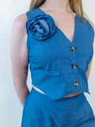 Close-up of denim-print vest with removable flower