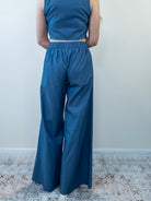 Model wearing denim-print pant set, back view