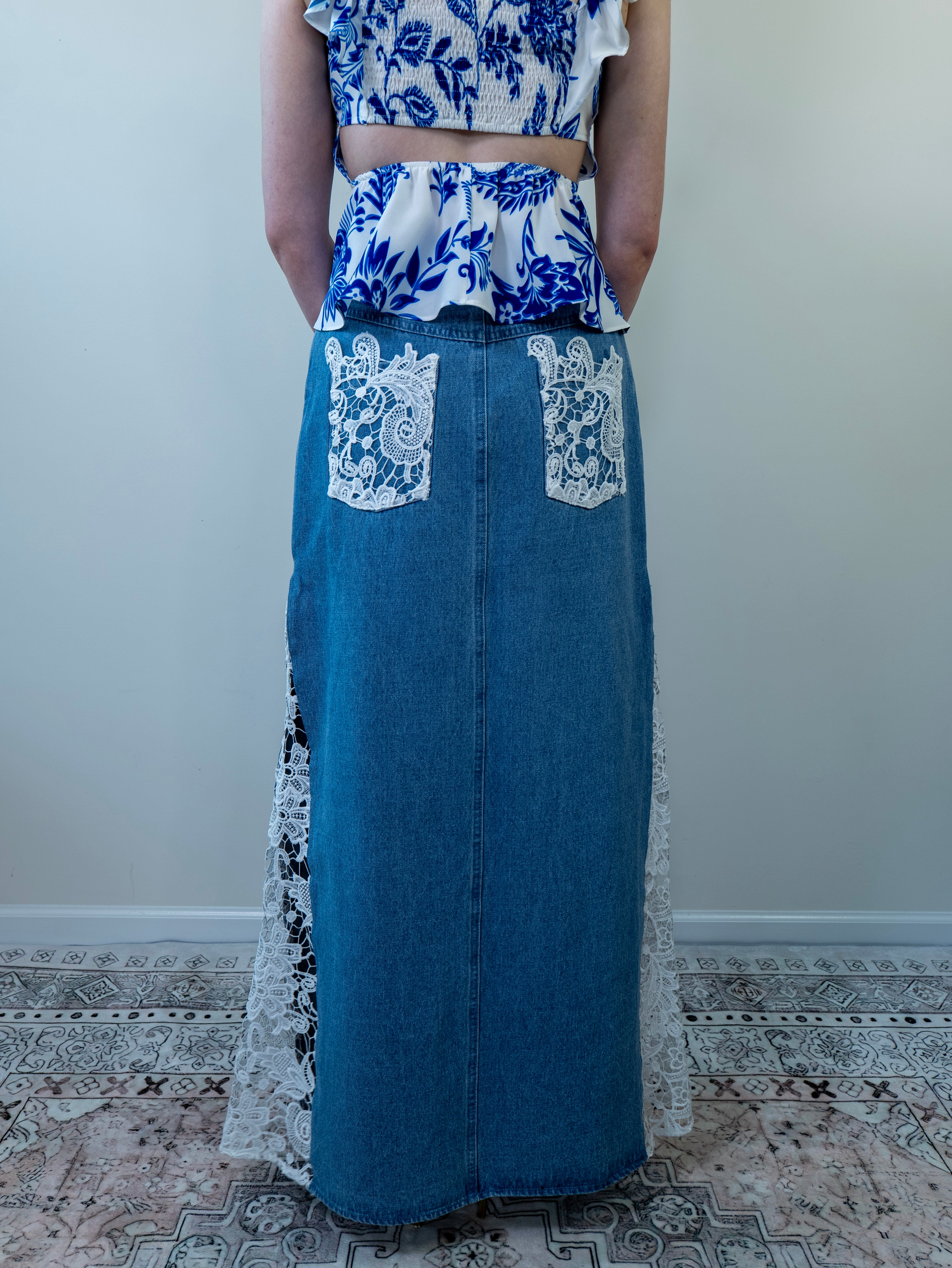 Back view of denim blue maxi skirt with crochet lace panel.