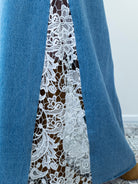 “Side view of crochet lace detailing on a denim blue maxi skirt.”