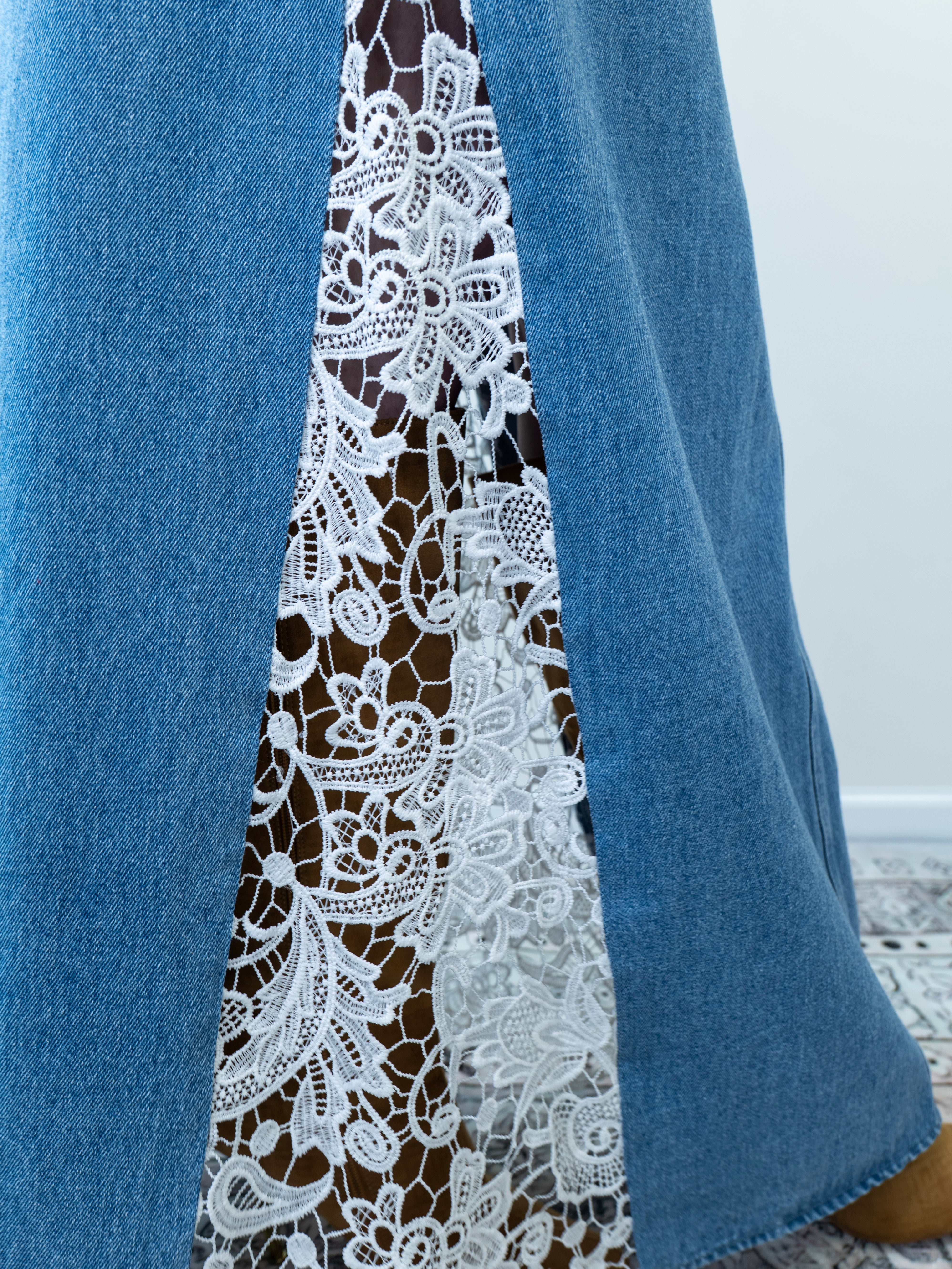 “Side view of crochet lace detailing on a denim blue maxi skirt.”