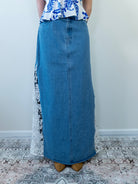 Model wearing a denim blue maxi skirt with crochet lace side panels, standing against a light background.