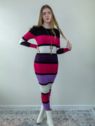 Model posing in multicolor ribbed midi sweater dress, showing right-side angle.