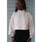 Dusty pink oversized cropped hoodie with balloon sleeves, thick drawstring, and 2-inch waistband for a relaxed, comfortable look. Model showing the  front of the crop hood top